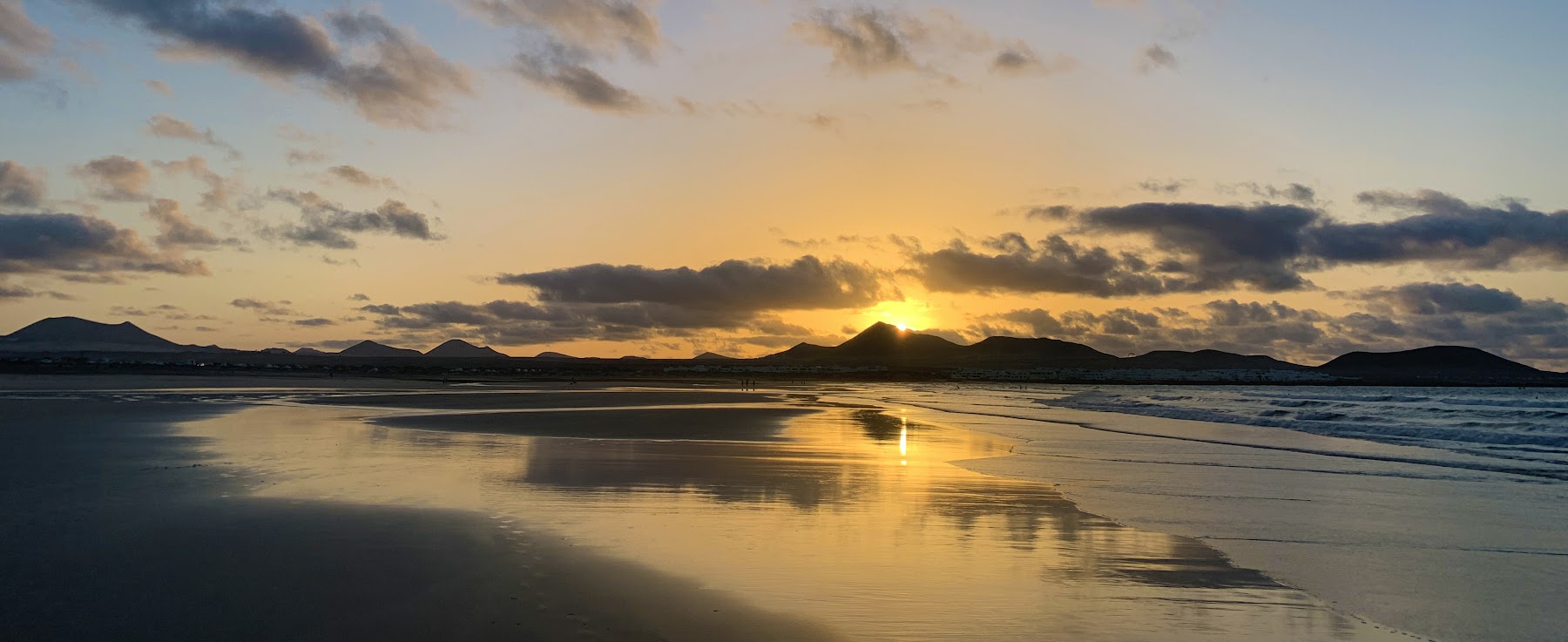 Sunset reflected on the wet sand of Famara beach