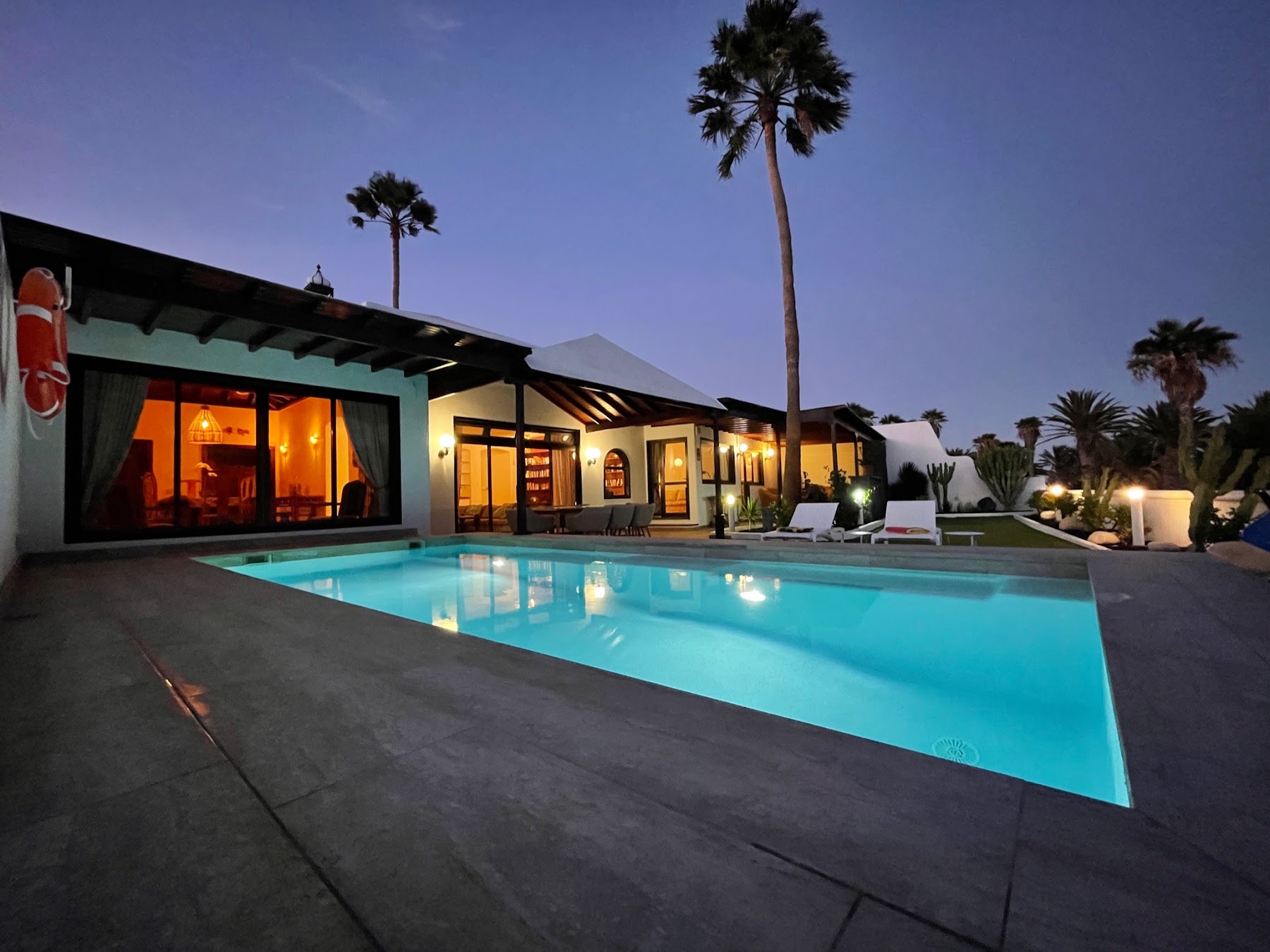 Villa Vista del Mar at dusk — the private pool glowing in front of the house
